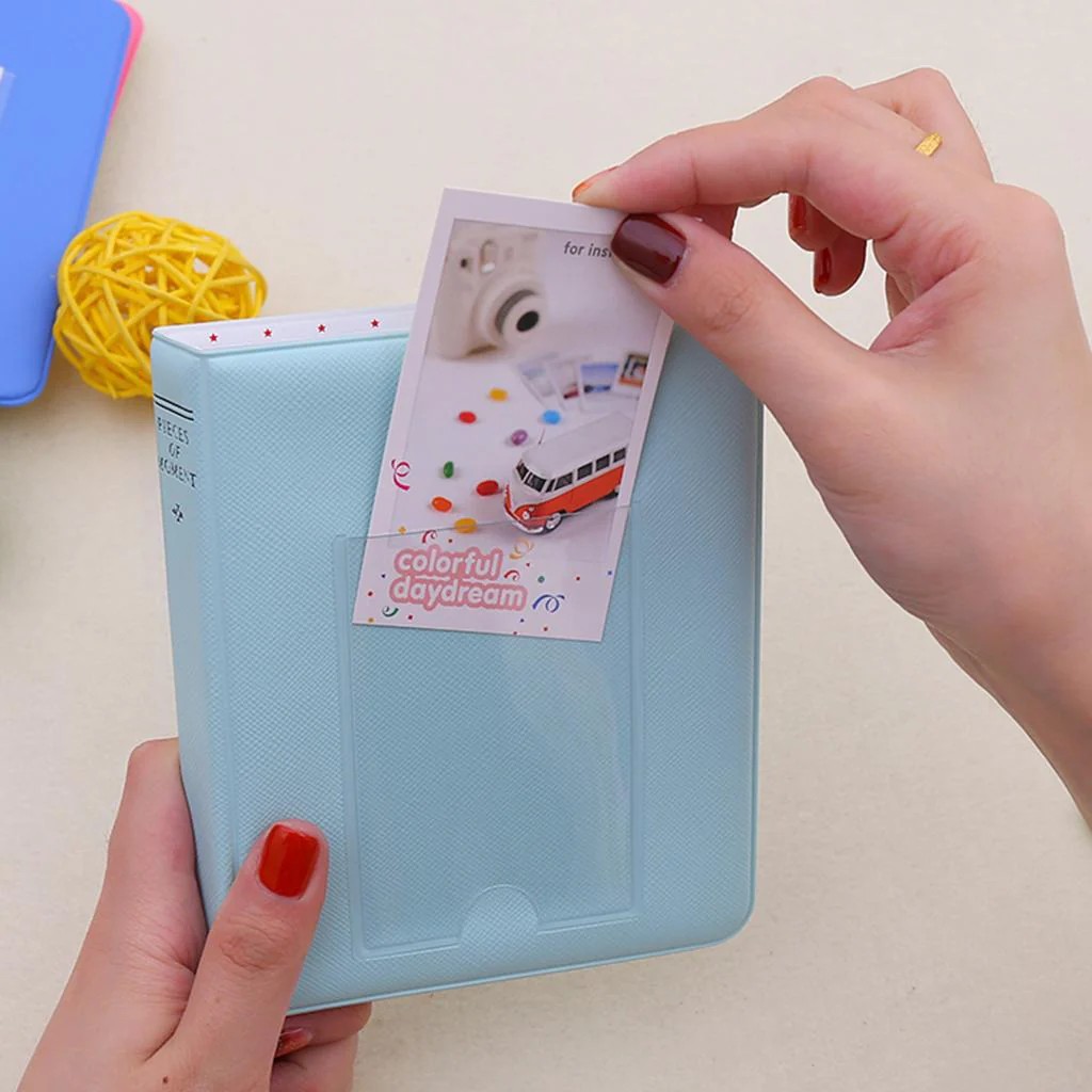 Фото INSTAX Mini вставляют в карман голубого фотоальбома